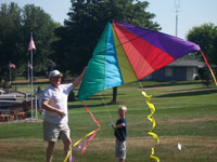 Auburn back pain free grandpa and grandson playing with a kite